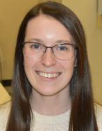 Head and shoulders photo of lab staff member with long dark hair and glasses